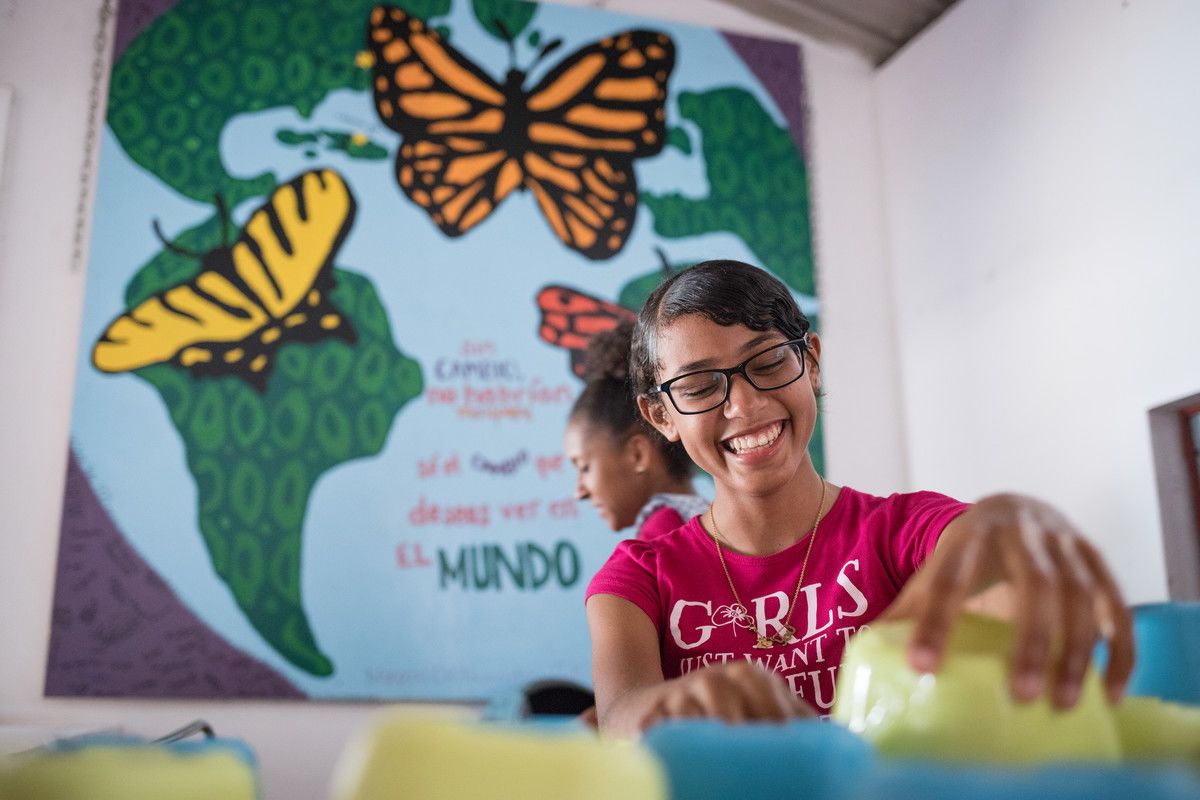 A girl smiles as she learns in one of the Mariposa classrooms