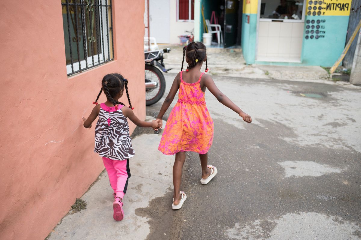 Two girls walk hand in hand through the streets